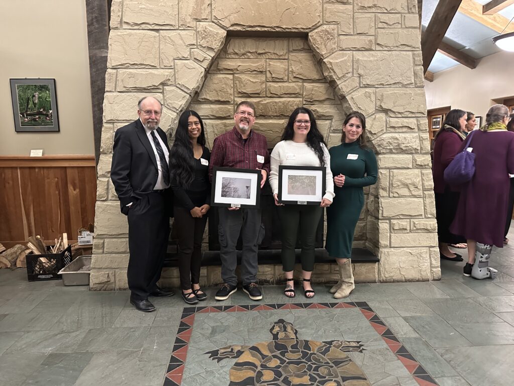 2023 Athens County 317 Board award winners. Pictured in front of the Lake Hope Lodge fireplace: Board member Ron Luce, board member Shei Sanchez, award winner Shawn Stover, award winner Jacelyn McGaughey, and board member Maeve Gallagher.